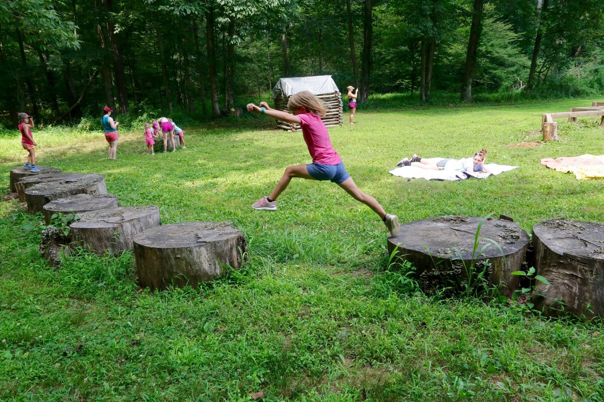 kids jumping on logs outside