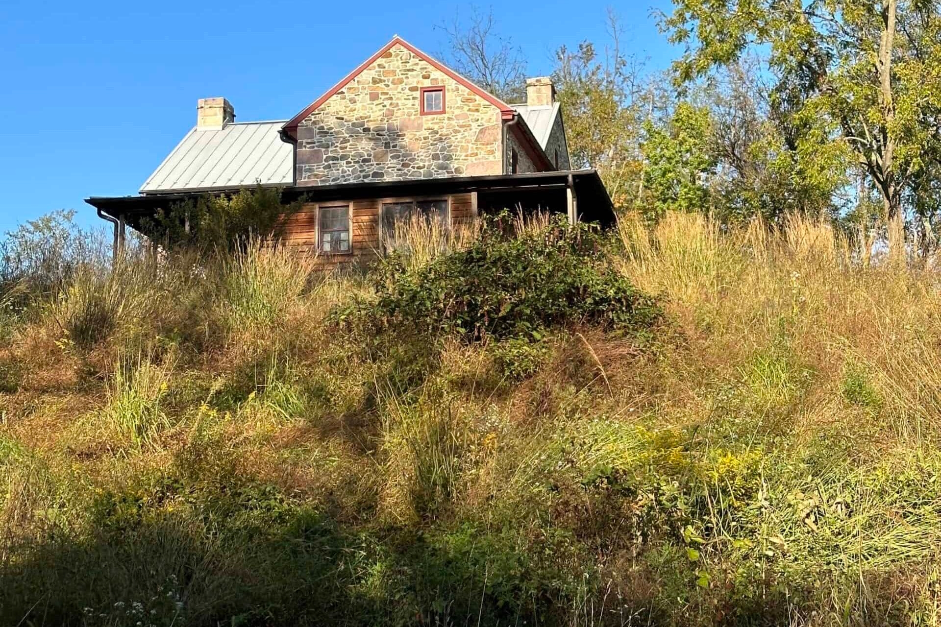 A house on a hill with a meadow growing around it